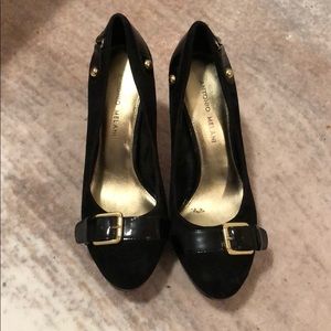 Black suede pumps with gold details.